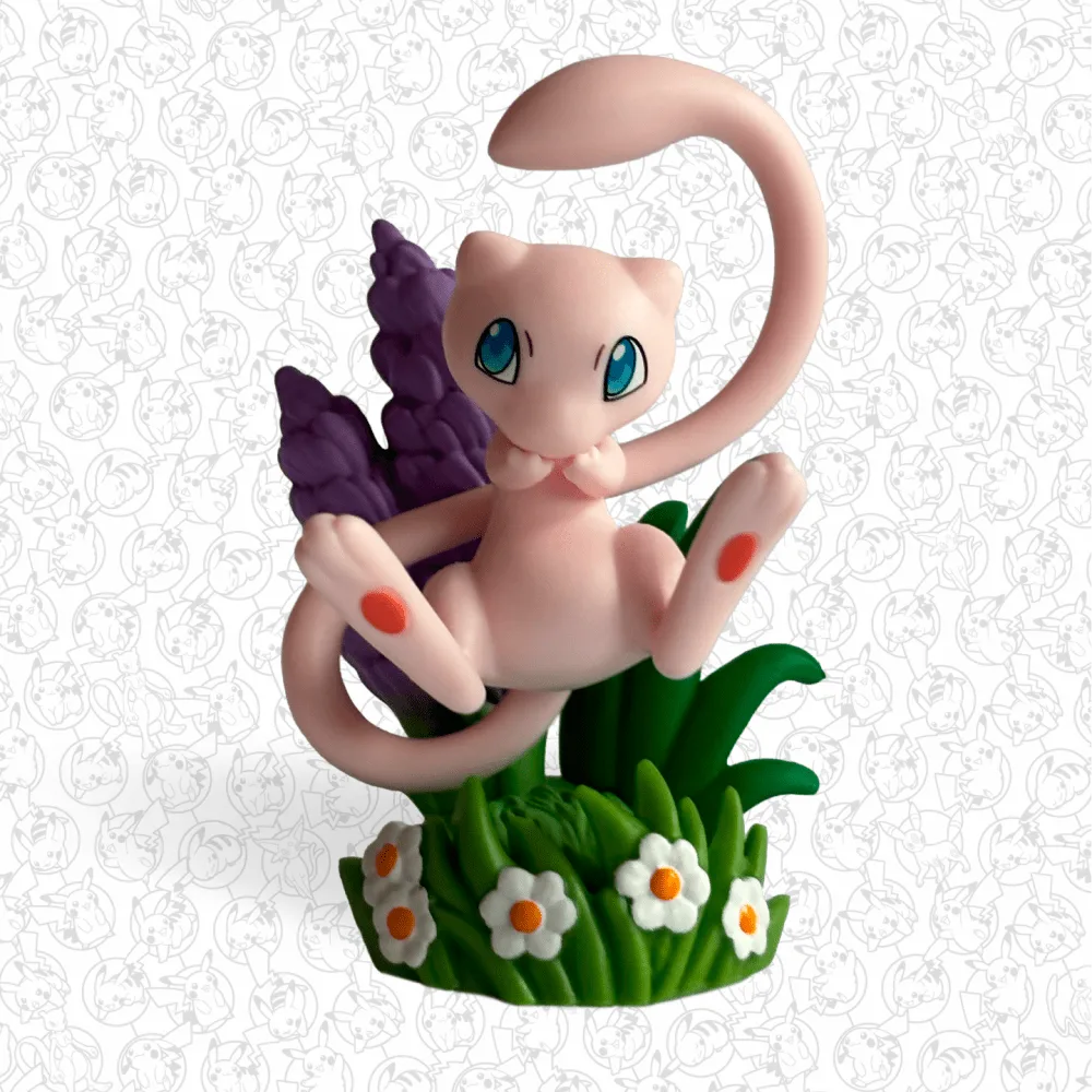 Figurine colorée de Mew assise dans l'herbe fleurie, incluse dans la Collection avec figurine Pokémon 30ᵉ Anniversaire